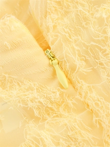 Détail du tissu à franges jaune avec fermeture éclair invisible assortie de près
