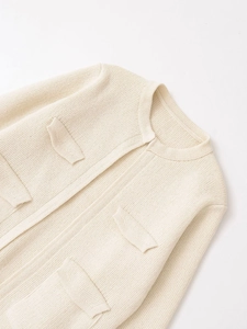 Dettaglio del cardigan in maglia beige con texture morbida e design a quattro tasche
