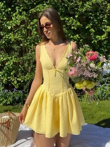 Détail de la robe d'été jaune style français avec décolleté en V et petit nœud