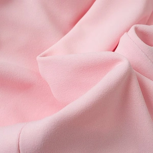 Macro de la texture du tissu rose avec des plis doux et des détails tissés subtils