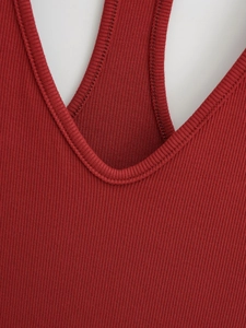 Détail du haut en tricot côtelé rouge foncé montrant les coutures de l'encolure et bretelles