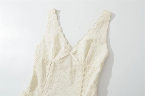 Détail de robe sans manches à col V avec broderie anglaise blanc cassé et bord festonné
