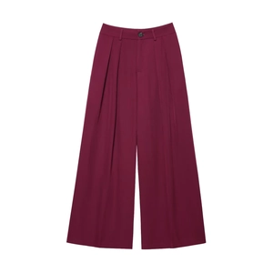 Close-up of wide-leg burgundy trousers featuring front pleats and a high-waisted button closure