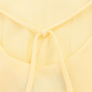 Detail of light yellow ramie blend dress featuring a delicate neckline drawstring tie
