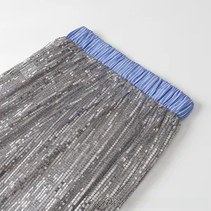 Détail macro de la taille élastique à rayures bleu blanc sur jupe à paillettes