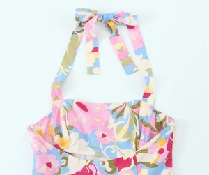 Vue détaillée d'une robe dos nu avec imprimé floral vif et nœud élégant à l'arrière