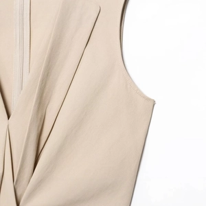 Beige sleeveless V-neck dress with pleated front design and hidden back zipper