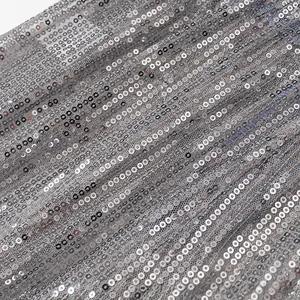 Détail macro de paillettes argentées scintillantes sur tissu mesh pour ensembles chic