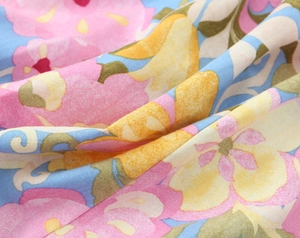 Gros plan détaillé du tissu à imprimé floral avec fleurs roses et jaunes sur fond bleu