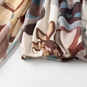 Detailansicht eines abstrakten Blumendrucks mit elastischem Bündchen an einer Bluse