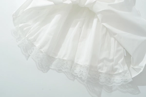 Détail de robe blanche avec tulle multicouche et bordure en dentelle florale raffinée