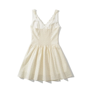 Détail de robe blanche en coton avec broderie anglaise et dos élastique froncé