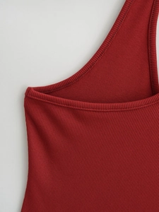 Détail du tissu en maille côtelée rouge foncé sur le débardeur moulant dos nu aux coutures nettes