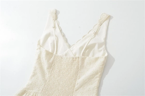 Détail de la broderie florale délicate et du smock sur cette robe blanche de style français