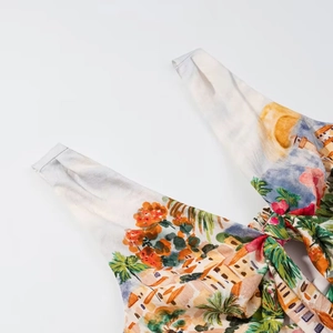 Détail du haut à imprimé méditerranéen avec nœud au décolleté et motifs de fleurs