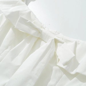 Robe blanche courte avec un grand nœud et des détails de volants élégants au décolleté