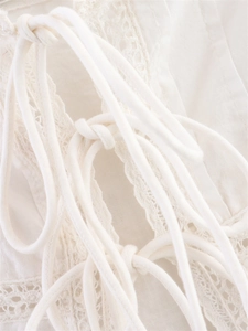 Close-up of white lace camisole showing delicate crochet details and drawstring tie