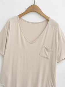 Close-up of a V-neck apricot short-sleeved t-shirt featuring a delicate chest pocket detail