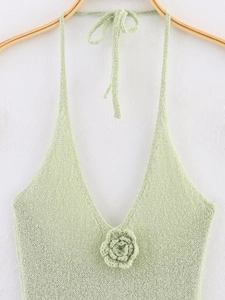 Détail du haut licou en maille vert clair avec fleur au crochet 3D et décolleté en V