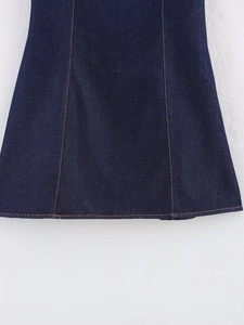 Detailed close-up of dark blue denim skirt hem with contrast yellow stitching and high-quality texture