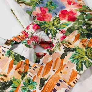 Gros plan sur la jupe à imprimé floral tropical avec plis élastiques et détail de nœud