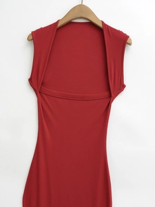 Dettaglio dell'abito smanicato in maglia a coste rosse con scollo a strati e taglio aderente