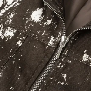 Makroaufnahme von Silber-Metallreißverschluss und Vintage-Druck auf brauner Jacke