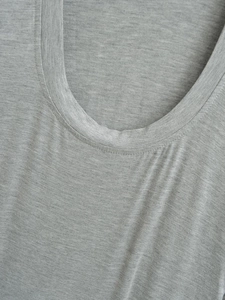 Detail of grey crewneck top showing high-quality knitted fabric texture and neat stitching