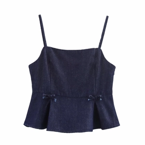Detail of dark wash denim camisole featuring delicate waist bows and ruffled hemline