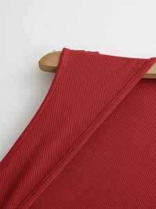 Dettaglio dell'abito in maglia rossa che mostra le cuciture di qualità sulla spalla