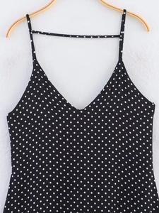 Detail of V-neck spaghetti strap dress with black and white polka dot pattern