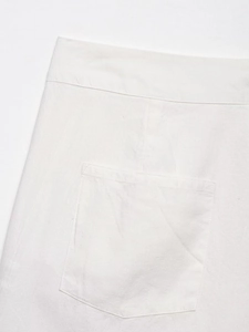 Detailed close-up of white cotton linen shorts featuring back pocket and neat stitching