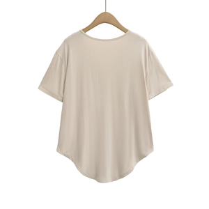 Detail view of beige short-sleeve T-shirt featuring a unique curved hem and back design