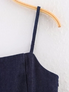 Detail of slim straps and dark blue denim fabric texture on a women's summer top