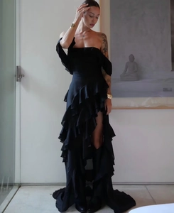 Elegant black off-shoulder satin maxi dress with layered ruffle hem and high slit detail
