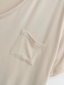Close-up detail of knitted fabric texture and square pocket stitching on short sleeve top