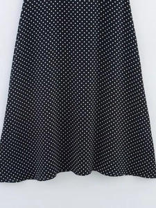 Detailed view of black polka dot fabric on a flowy A-line long skirt for women
