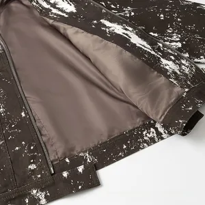 Dettaglio della giacca in tela marrone vintage con stampa bianca e cerniera in metallo