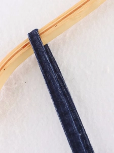 Detail shot of navy blue denim straps showing twill fabric texture and stitching