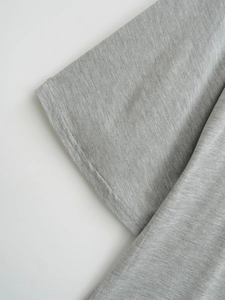 Detailed close-up of double-needle stitching on dark gray knitted fabric sleeve