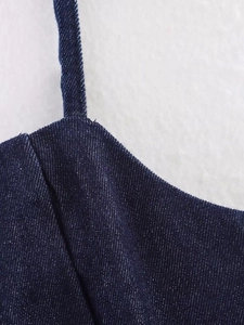 Close-up detail of dark blue denim camisole with focus on strap stitching and fabric texture