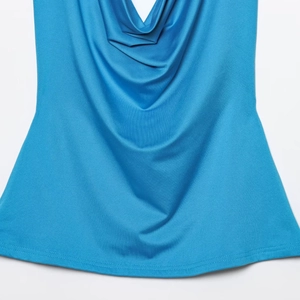 Detail of blue sleeveless top featuring a cowl neck and fine knit texture fabric
