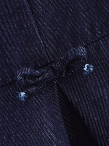 Macro detail of dark blue denim fabric with drawstring bow tie and twill texture