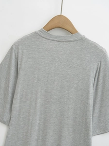 Detail of grey short-sleeve T-shirt fabric with classic crew neck on wooden hanger