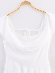 Détail du décolleté de la robe blanche avec drapé naturel et texture plissée douce
