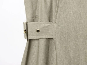 Detailed close-up of the linen fabric texture and gold metal buckle on the midi skirt
