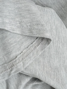 Macro view of grey knitted fabric texture with professional double-needle stitching detail