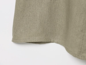 Detailed close-up of fine stitching on a sage green linen midi skirt with natural texture