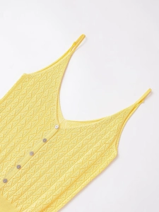 Détail d'un caraco en maille jaune avec boutons délicats et texture de losange évidée