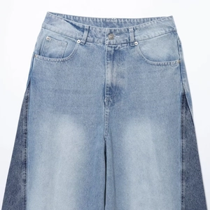 Flat lay of high waist straight jeans with light blue and dark blue patchwork design